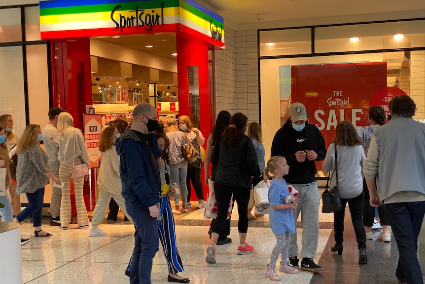 Shoppers outside a store in a shopping mall