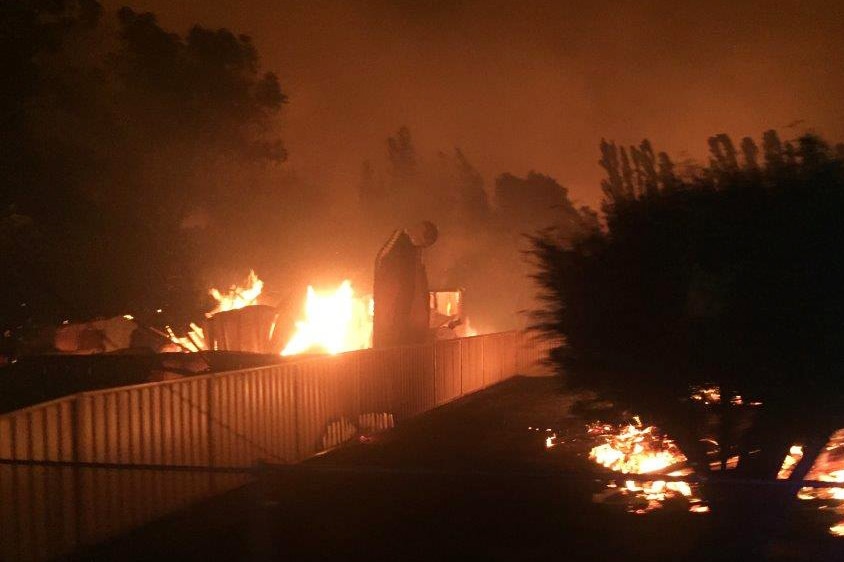 A burning building and scrub lights up the night in Yarloop.