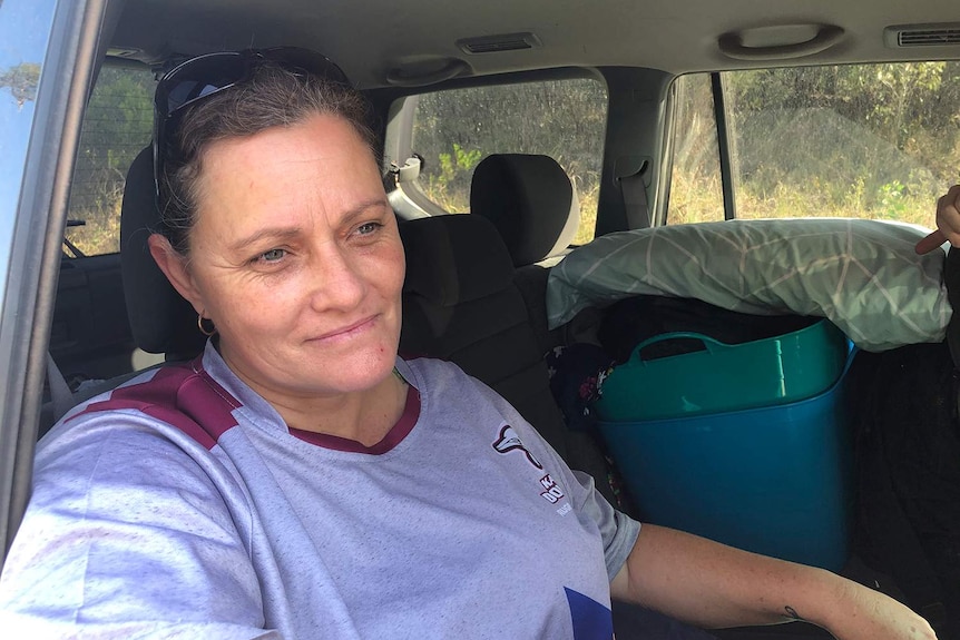 Leanne Thomas sits in her car unable to go home for the second time in months as fires threaten her home.