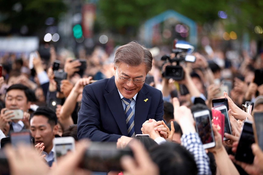 Presidential candidate Moon Jae-in moves through a thick crowd of supporters.