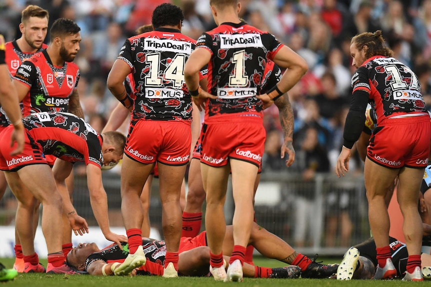 Tyson Frizell lies on the ground concussed as his Dragons teammates surround him.