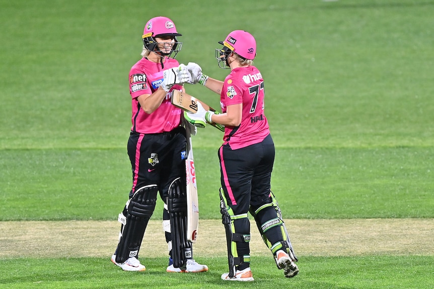 Ashleigh Gardner fist pumps Alyssa Healy of the Sixers after she scores a half century