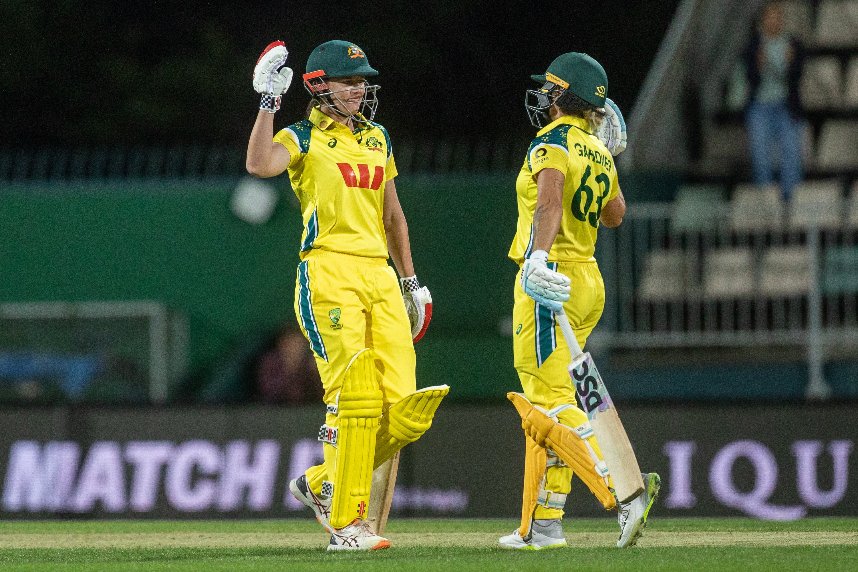 Tahlia McGrath and Ash Gardner celebrate in the middle of the pitch, while batting, after hitting the winning runs