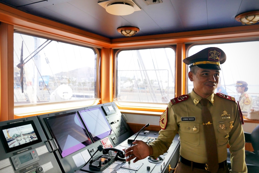 An indonesian navy cadet in the cockpit of an Indonesian navy tall ship