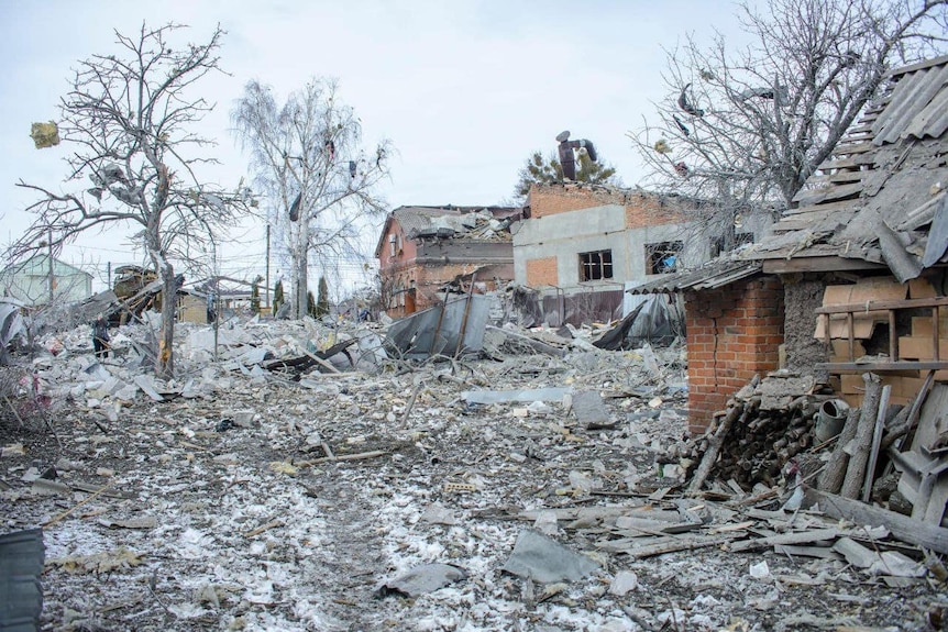 Debris from bombed houses cover an entire street