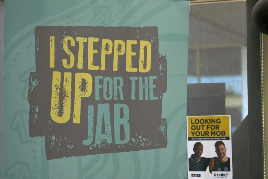 A sign on a wall says 'I stepped up for the jab'