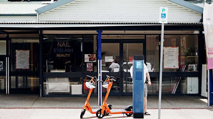 Two scooters are seen from across a road in the Darwin CBD.