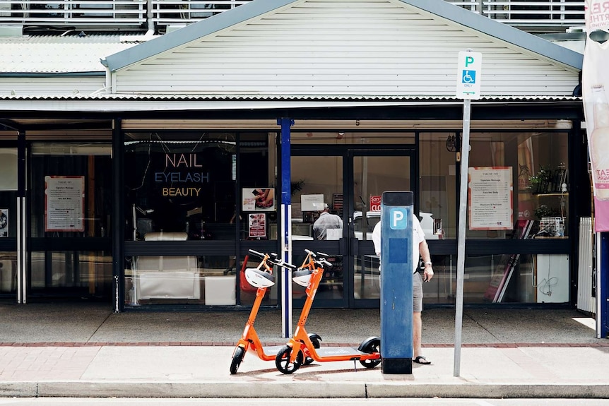 Two scooters are seen from across a road in the Darwin CBD.