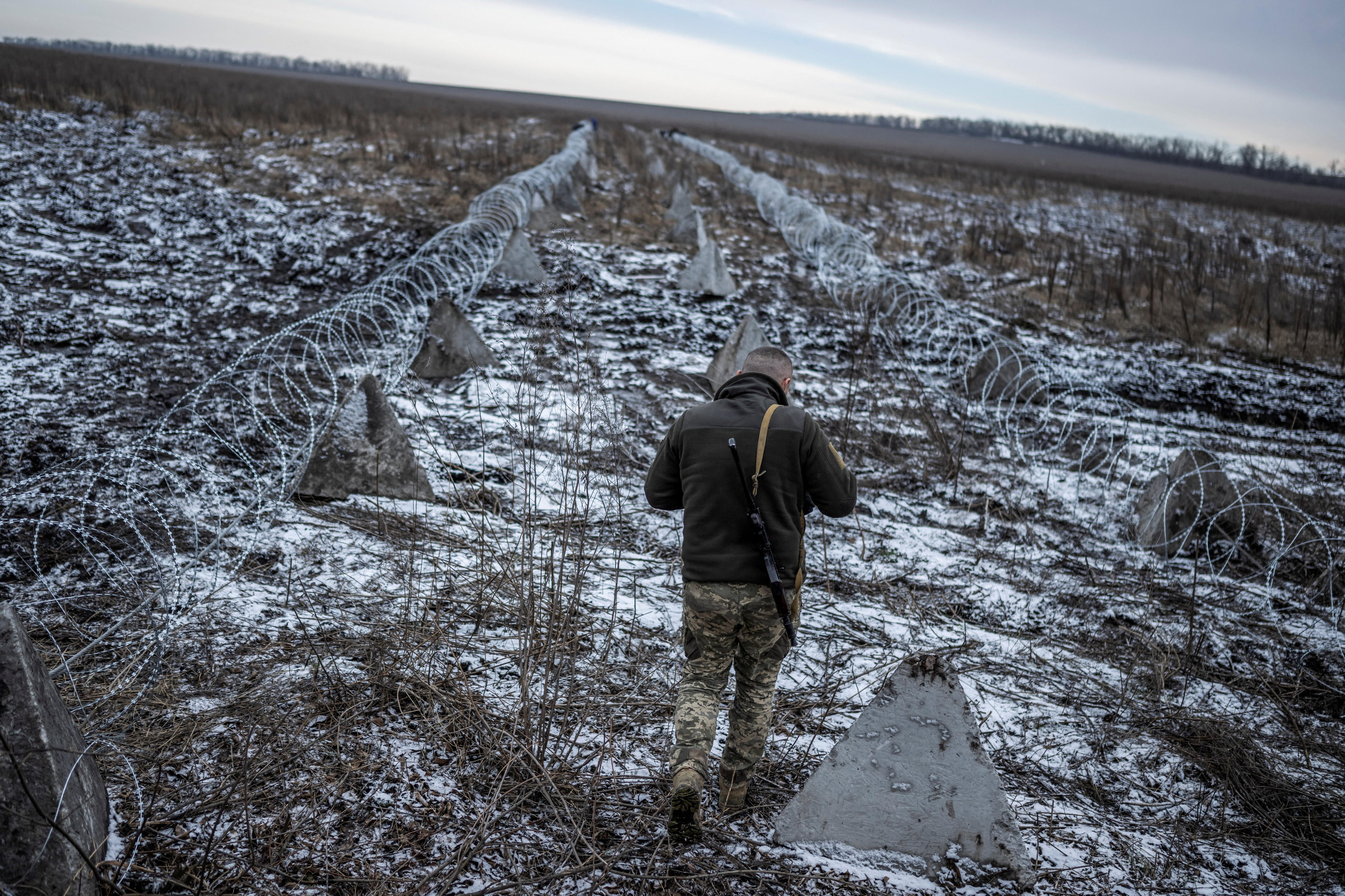 A man walking in an empty field. 