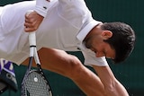 Novak Djokovic almost does the splits but leans on this racquet to stop himself from falling further