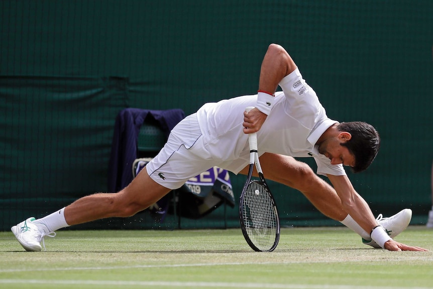 Novak Djokovic almost does the splits but leans on this racquet to stop himself from falling further