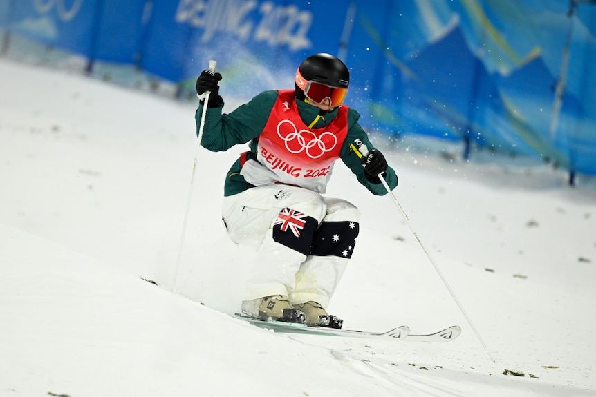 An Australian female moguls skier goes down the course at the Beijing Winter Olympics.