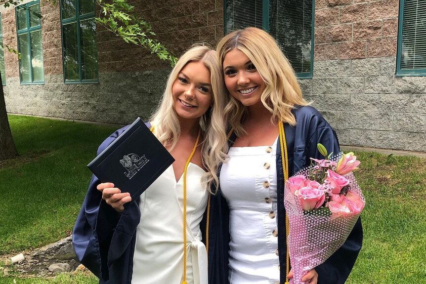 Two young women in graduation gowns 