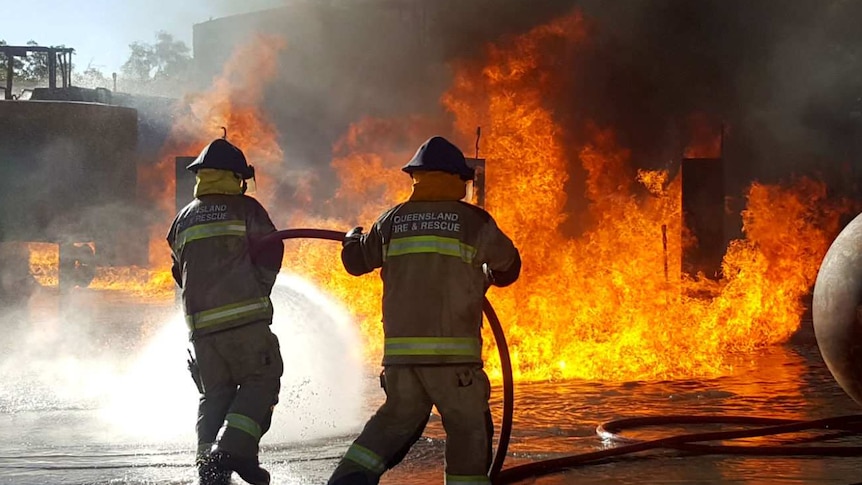 Firefighters spray a large fire