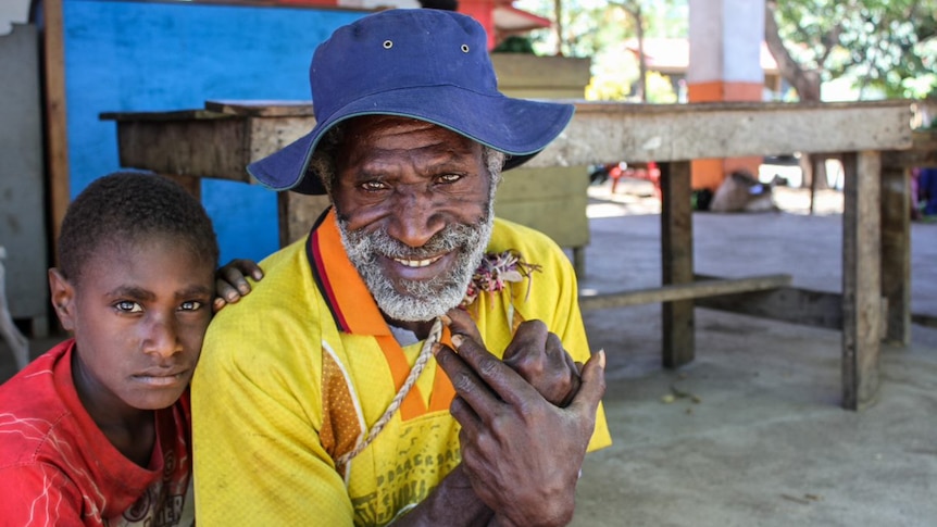 A man and child at Blackman Town markets on the island of Tanna in Vanuatu.
