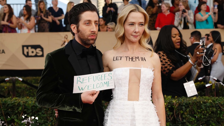 Actor Simon Helberg and his wife actress Jocelyn Towne protest the US immigration ban on the SAG Awards red carpet.