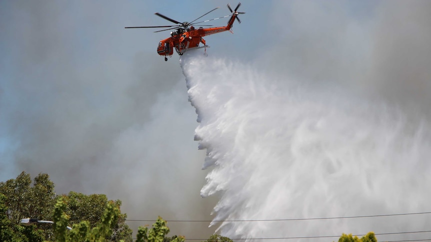 A helitac sprays water on a fire in Jolimont in Perth's western suburbs.