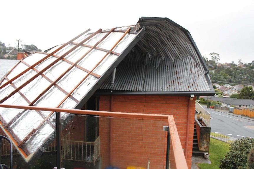 A roof peeled back to show the inside from strong wind