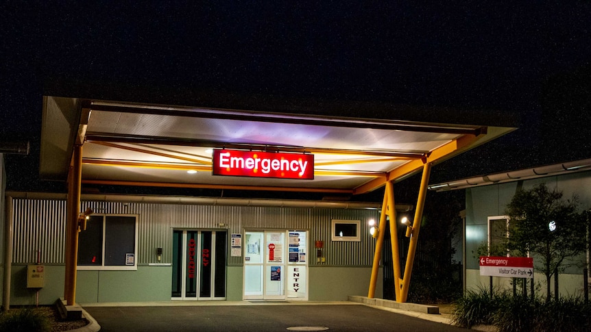 The emergency sign at Narrabri hospital glowing in the night over the entrance.