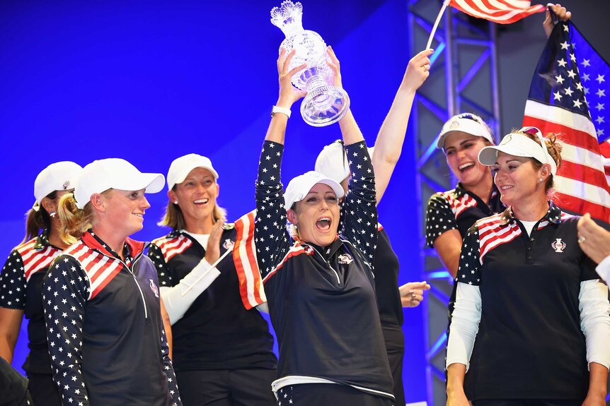 Team USA's Cristie Kerr holds the Solheim Cup trophy after her team beats Europe