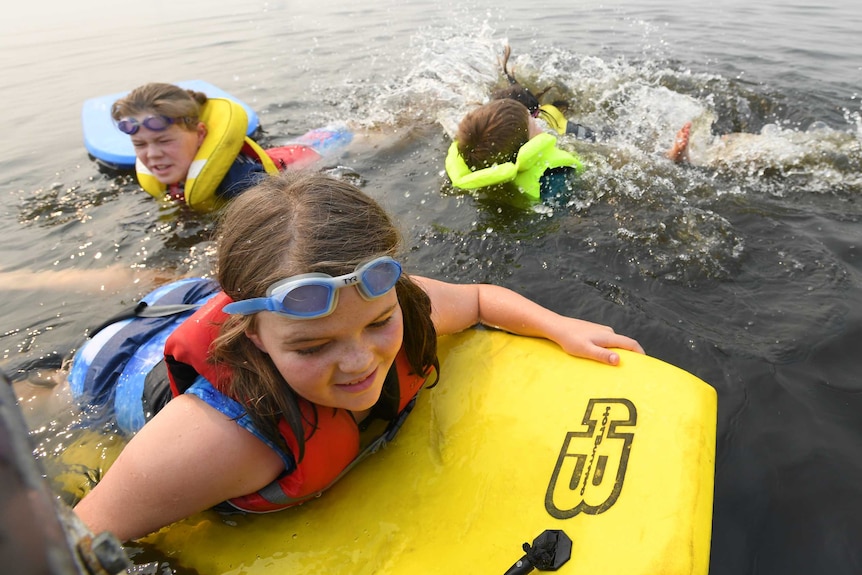 Children cool off in the water