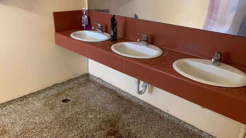 Sinks in a bathroom with a discoloured floor
