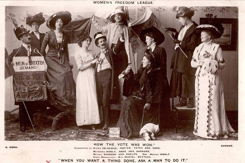 Old black and white photograph of men and women dressed in theatrical costumes advocating for Women's Freedom League.