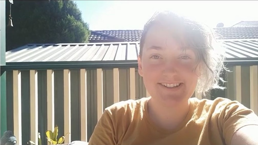 CourtneyJade smiling in the sunshine in a selfie video.