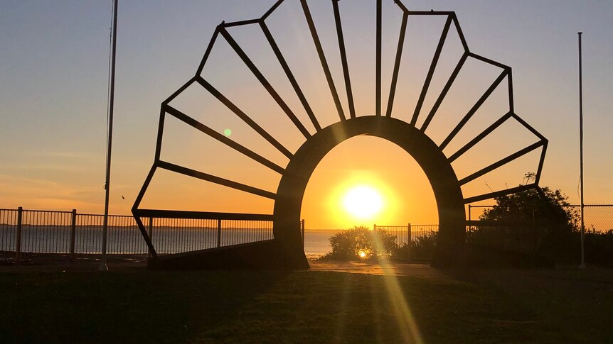 An archway with the sun rising.