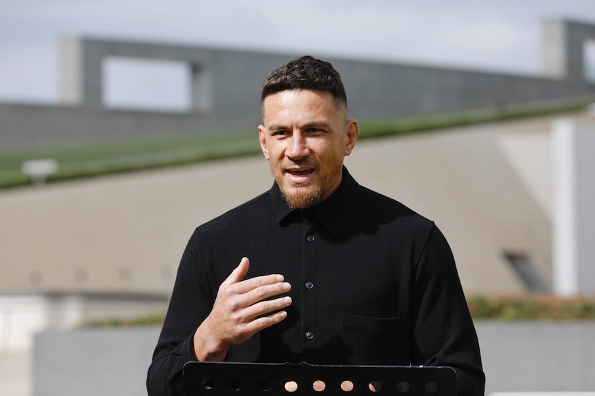 A man talks in front of Parliament House