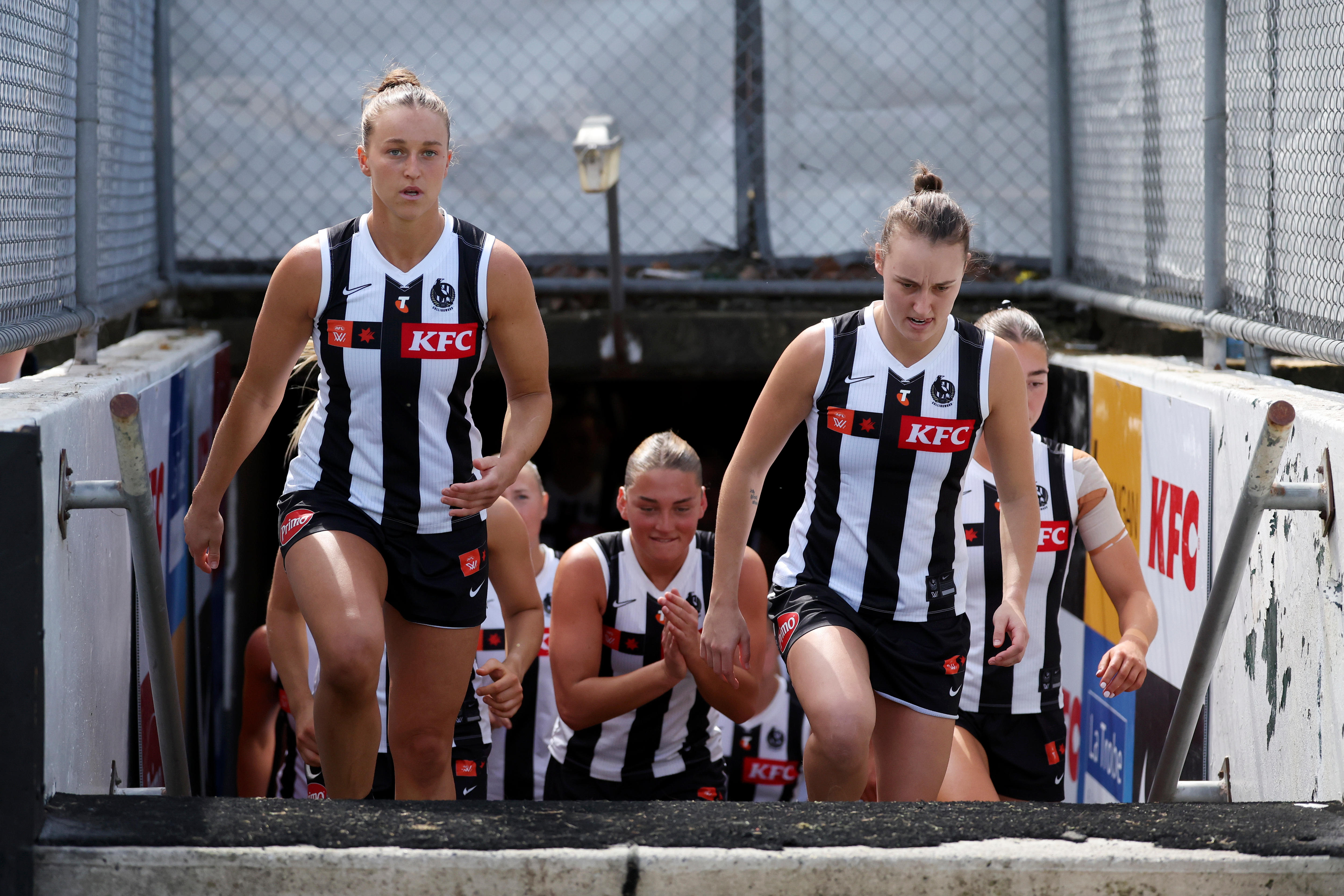 Ruby Schleicher of the Magpies, Ashley Centra of the Magpies and Jordyn Allen of the Magpies enter the ground.