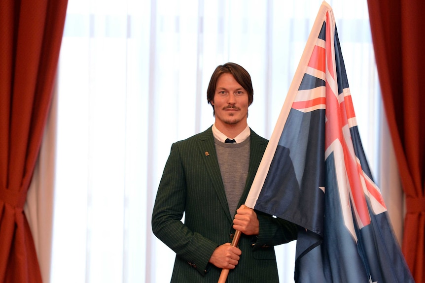 Australian snowboarder Alex Pullin holds the Australian flag ahead of the Olympic Winter Games opening ceremony in Sochi.