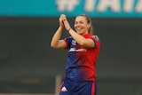 Tara Norris of Delhi Capitals claps in the air and smiles after taking a wicket.