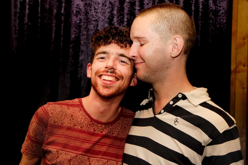 A gay couple standing together in Closet bar in Melbourne.