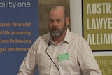 TV still of Brisbane barrister Stephen Keim speaking at a legal conference on the Gold Coast