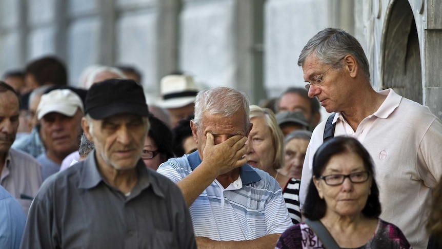 People queue as they wait outside a National Bank branch to open in Athens, Greece July 20, 2015.