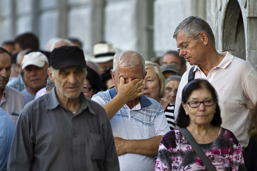 People queue as they wait outside a National Bank branch to open in Athens, Greece July 20, 2015.