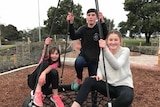 The Desmond children of Launceston sit on a swing.