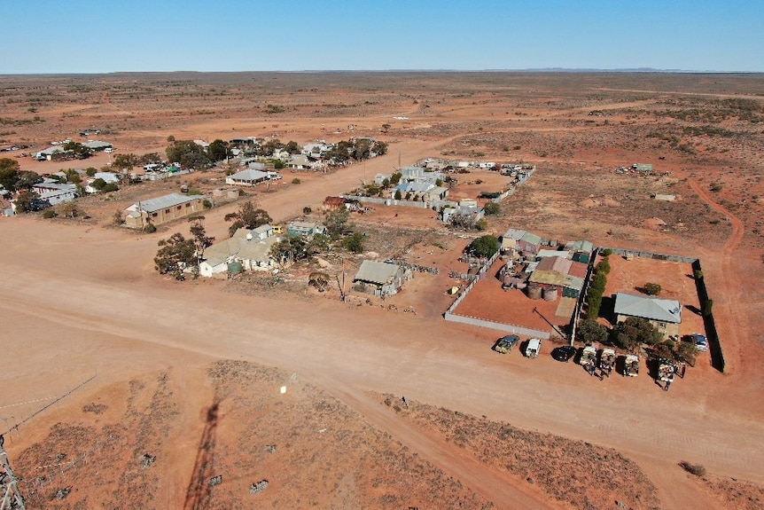 A small town surrounded by red dirt from the air