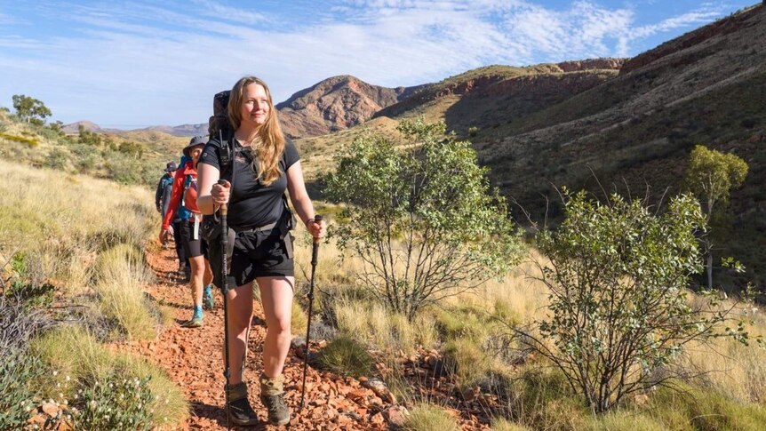 A woman leads hikers through the outback
