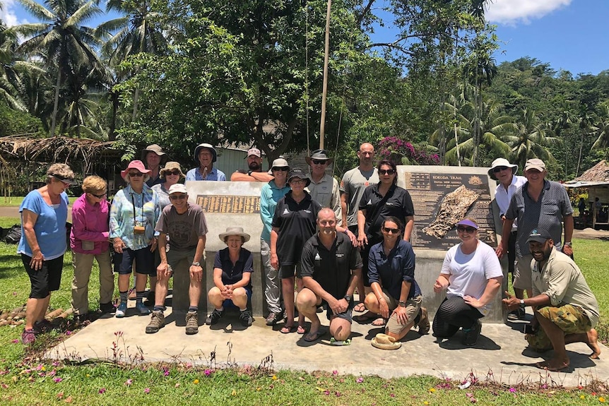 About 20 descendants of fallen WWII Australian soldiers stand around a monument unveiled in Gorari.