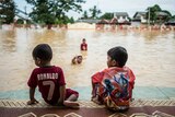 Two boys look on as their friends play in floodwaters in Pengkalan Chepa, near Kota Bharu on December 27, 2014
