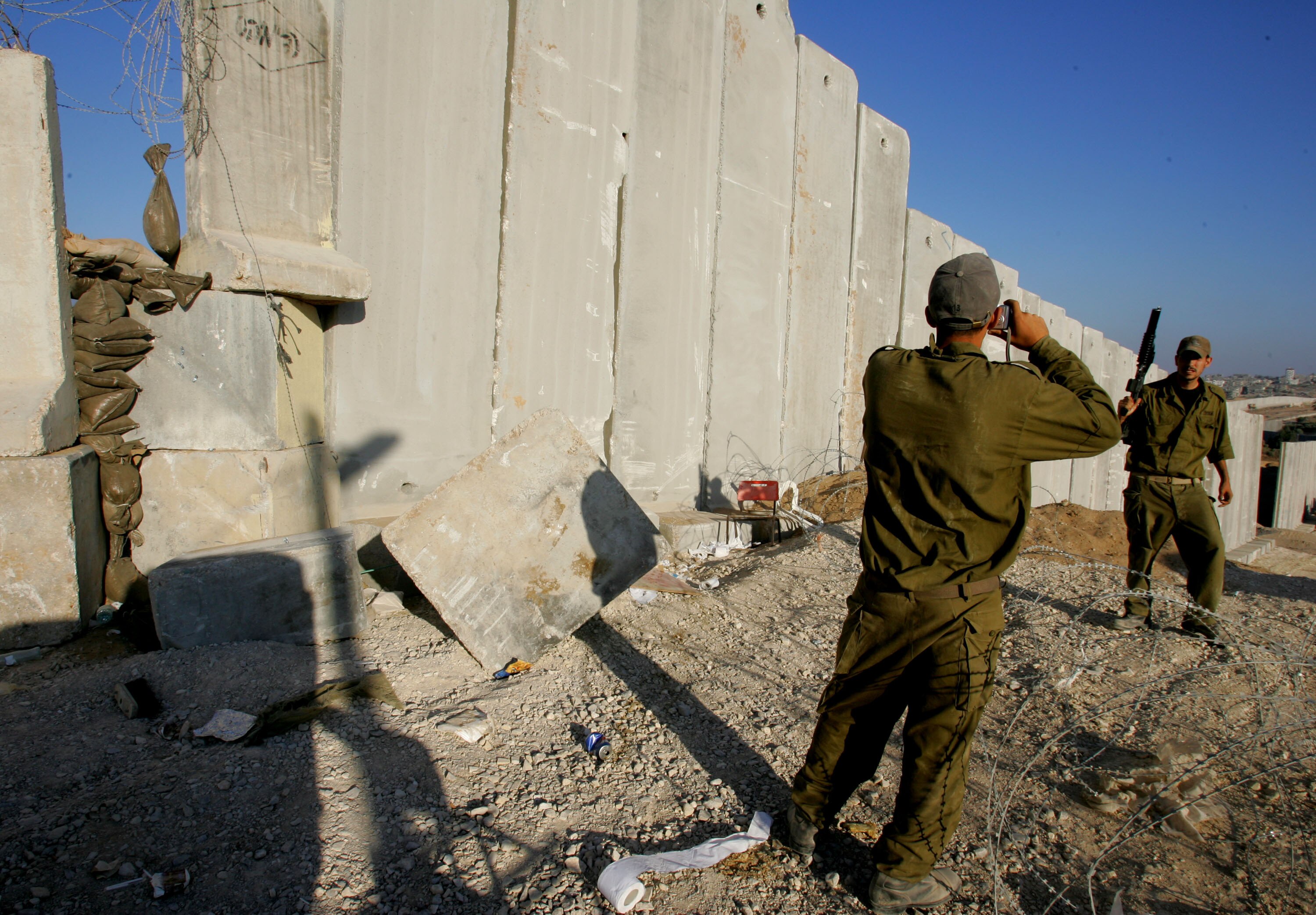 An Israeli soldier poses for souvenir photos along Israel's protective barrier.