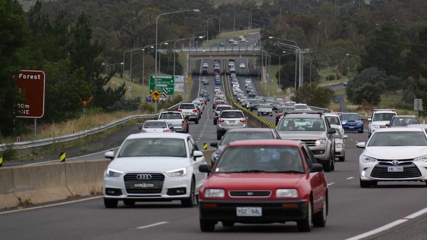 Cars travel both directions on a dual carriageway road.