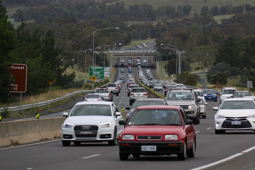 Cars travel both directions on a dual carriageway road.