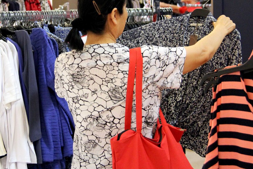 A shopper inspects a garment in a department store.