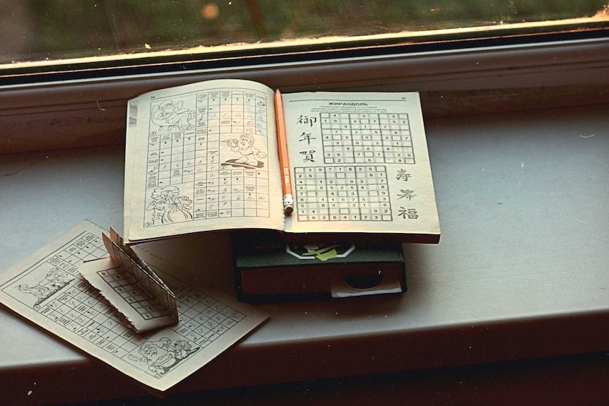 Book of Sudoku puzzles lying opening on a windowsill.