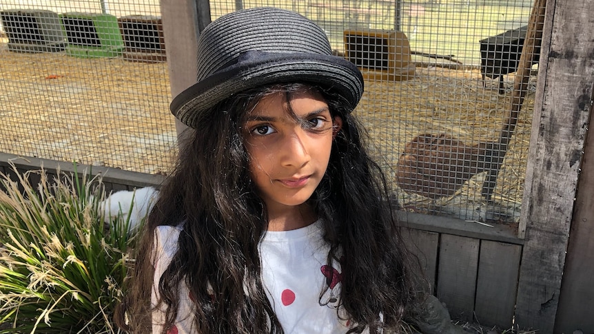 A young girl wearing a grey hat