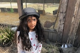 A young girl wearing a grey hat