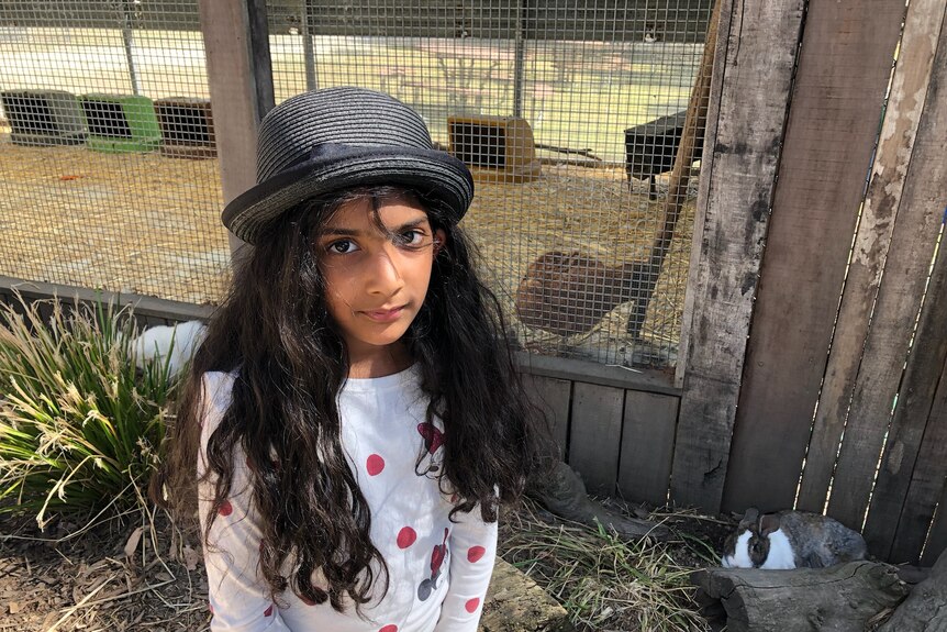 A young girl wearing a grey hat